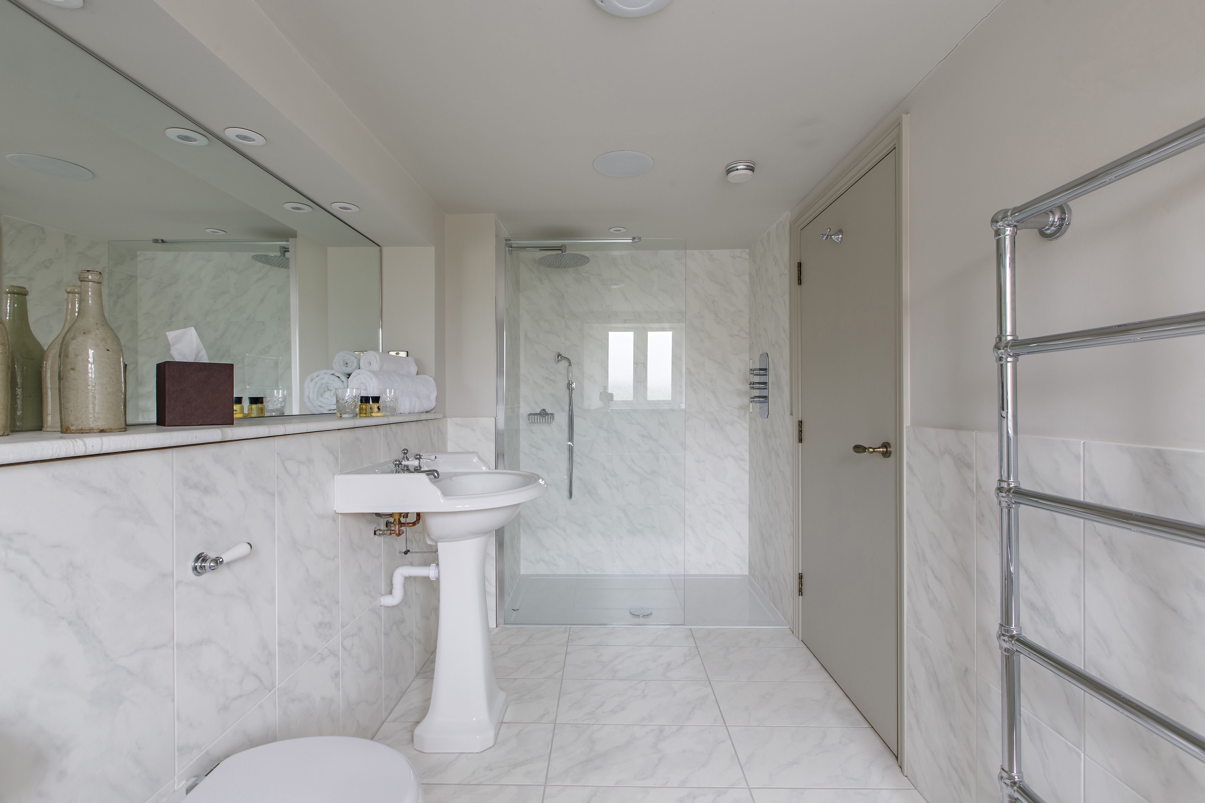 A modern bathroom with a white sink, mirror, and shower.