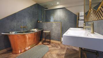 Une salle de bain moderne avec une baignoire sur pieds, un meuble-lavabo et un miroir.