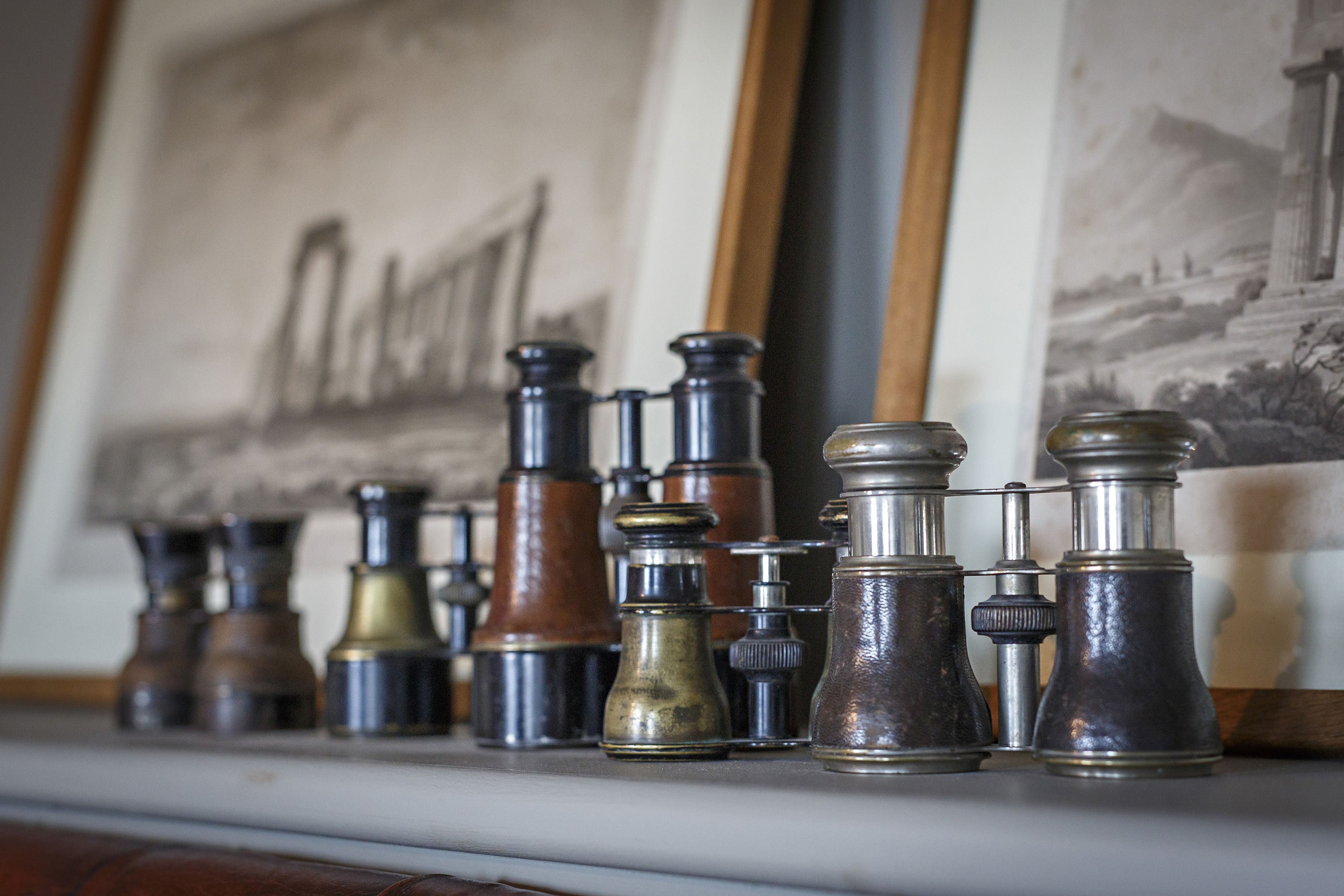 A collection of antique binoculars on a shelf.