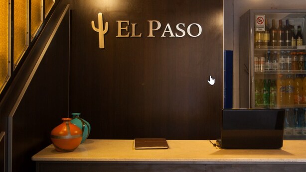 Una recepción con un letrero que dice "EL PASO" y un refrigerador lleno de bebidas.