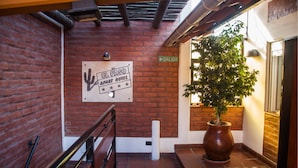 Un muro de ladrillo con un letrero que dice 'El Paso Apart Hotel' y una planta en maceta.