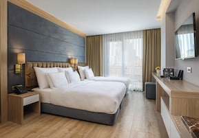 Habitación triple Deluxe | Minibar, caja fuerte, escritorio y espacio para trabajar con un portátil