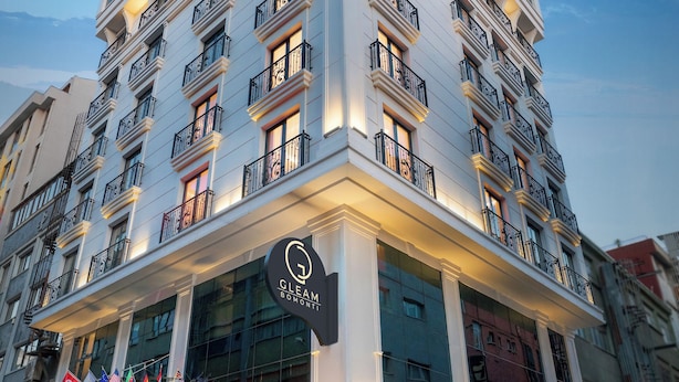 A multi-story hotel with a modern facade, balconies, and a well-lit entrance. - Gleam Bomonti Hotel (Istanbul)