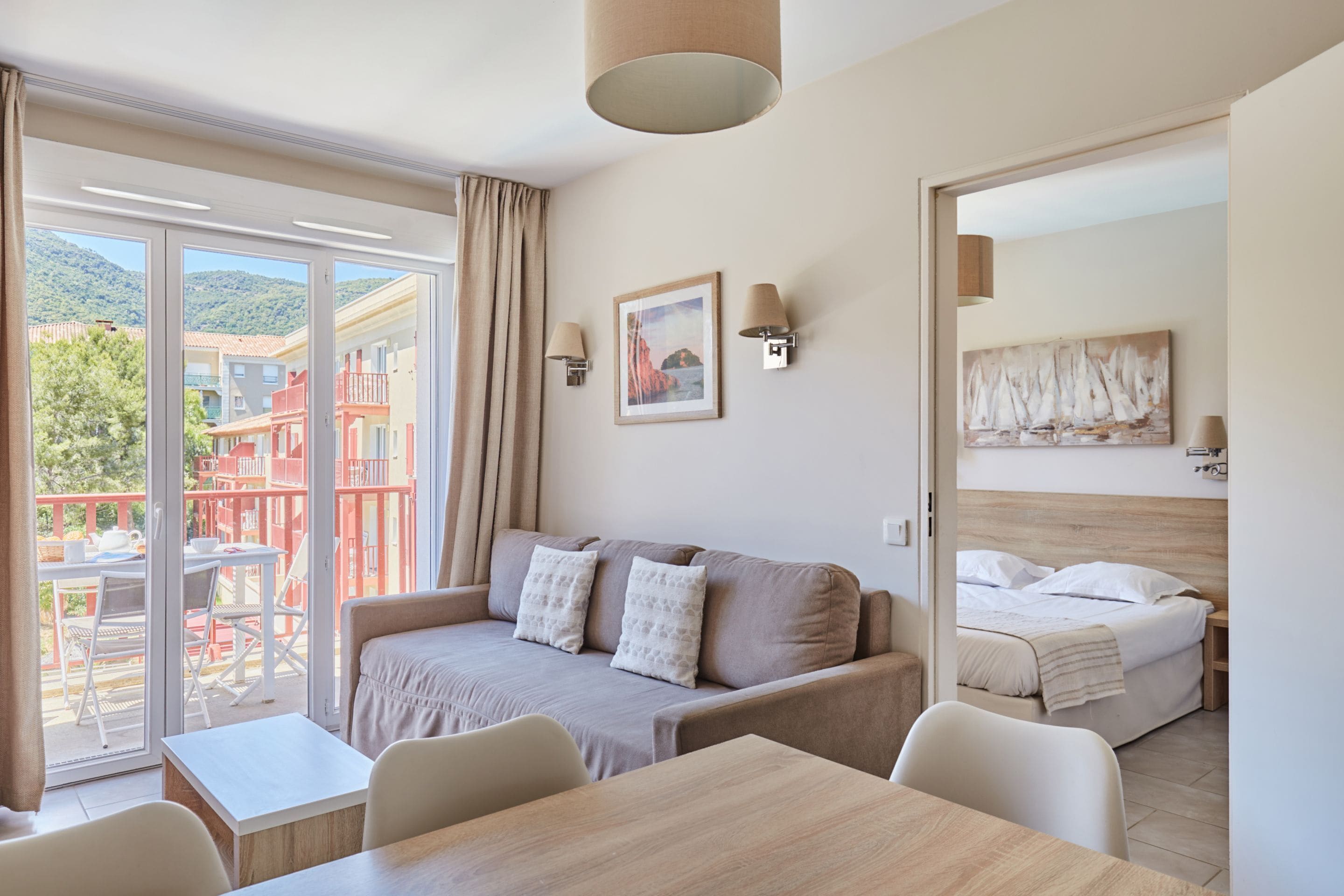 Een moderne hotelkamer met een bank, een eettafel en een bed.