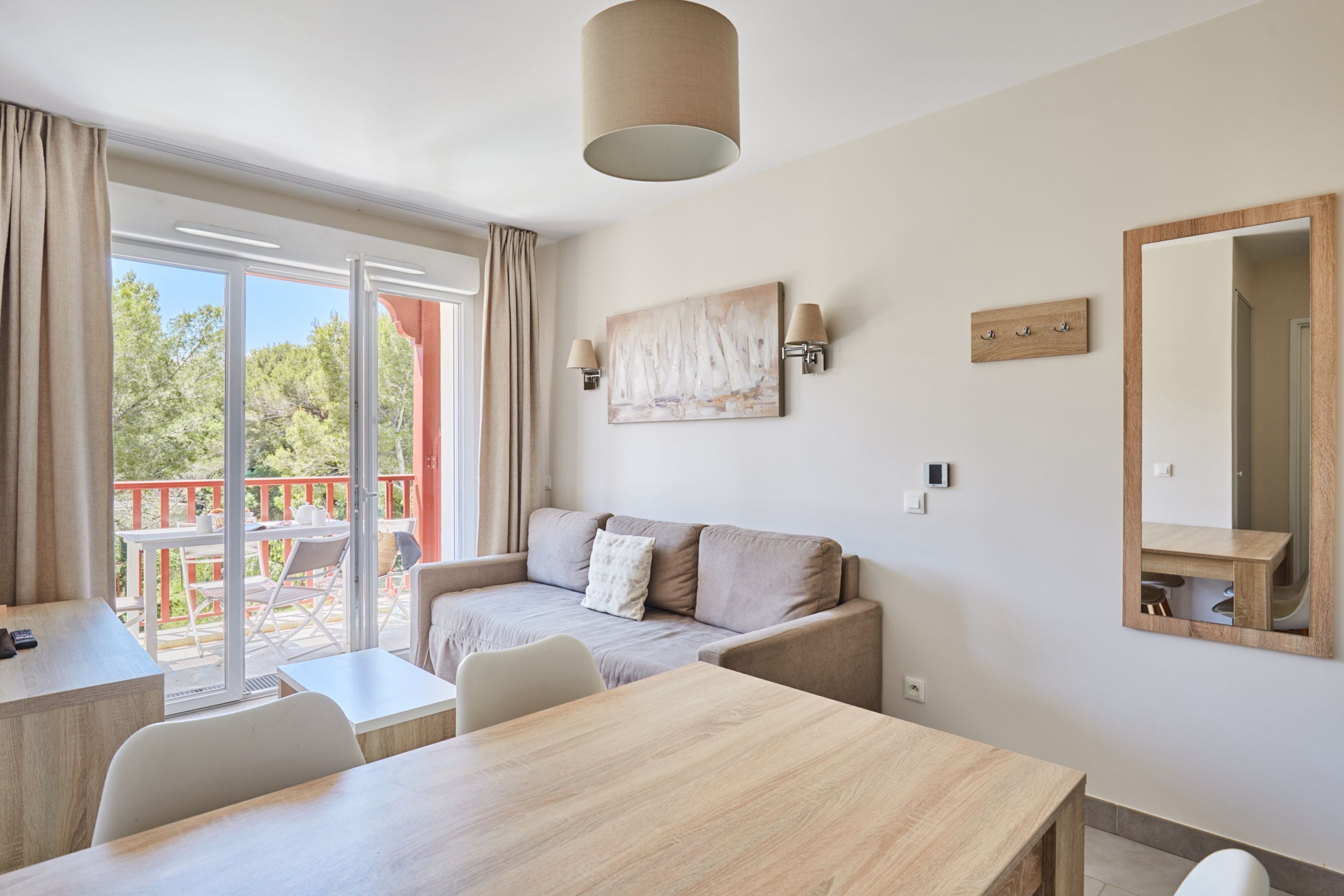 Una habitación moderna con sofá, mesa de comedor y un espejo grande.