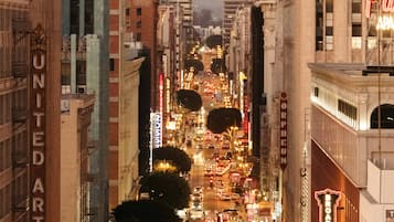 A nighttime city street with buildings, streetlights, and illuminated signs.