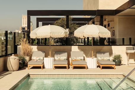 Una piscina al aire libre, camas de piscina gratis, sombrillas