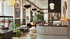 A modern lobby with a reception desk, seating area, and a snack bar. - The Hoxton, Downtown LA (Los Angeles)