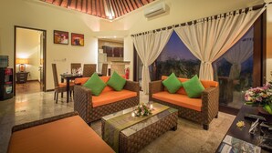 A living room with wicker furniture, a coffee table, and a view of the outdoors. - 2 Bedroom villa near Pandawa Beach (Uluwatu)