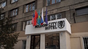 The exterior of the Mildom City Hotel with flags of the USA, Kazakhstan, and the European Union. - Mildom City Hotel (Almaty)