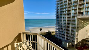 A balcony with a view of the beach and a high-rise building. - Royale Palms 602H Oceanview Studio in Kingston (Myrtle Beach)