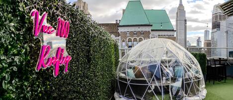 A dome tent on a rooftop with a sign reading "Viva 100 Rooftop".