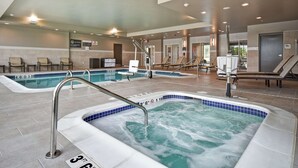 Ein Hotelpoolbereich mit mehreren Whirlpools und Liegestühlen.