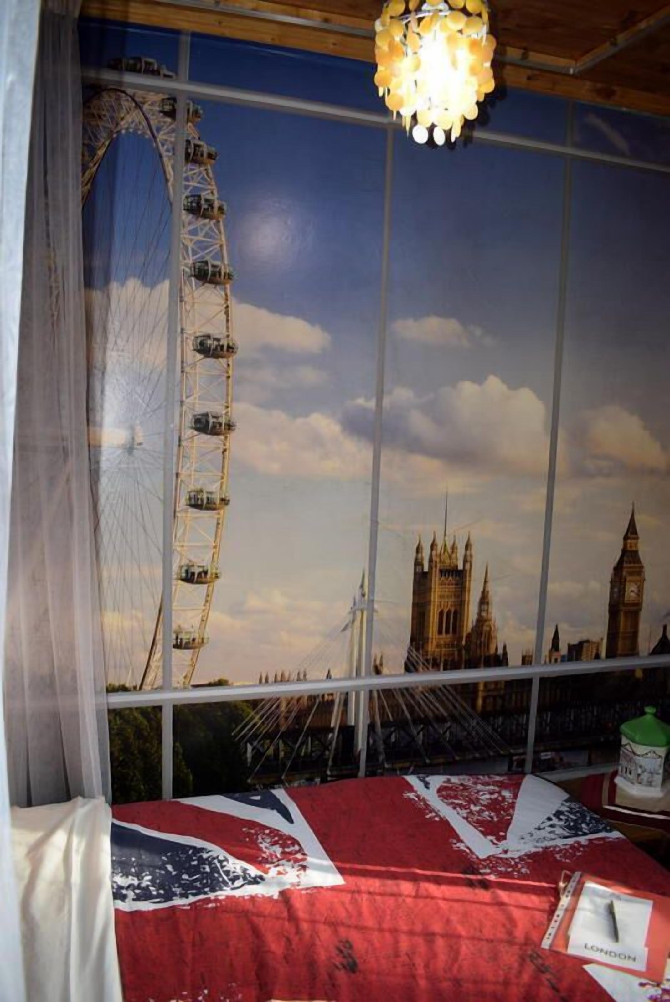 Een kamer met een groot raam en uitzicht op de London Eye en Big Ben.
