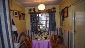 A dining area with a table set for four, surrounded by wooden chairs.