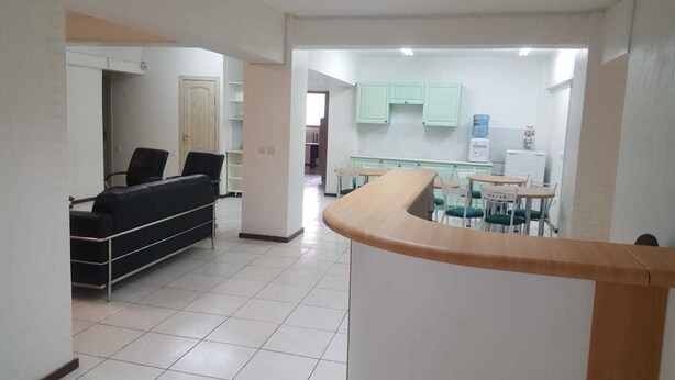 Een kamer met een bed, een bureau en een kitchenette.