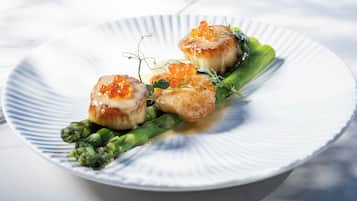 A plate with seared scallops, caviar, and asparagus.