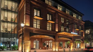 A JW Marriott hotel with a brick facade, large windows, and a well-lit entrance area. - JW Marriott Savannah Plant Riverside District (Savannah)