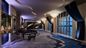A grand hallway with a grand piano, large windows, and a chandelier. - JW Marriott Savannah Plant Riverside District (Savannah)
