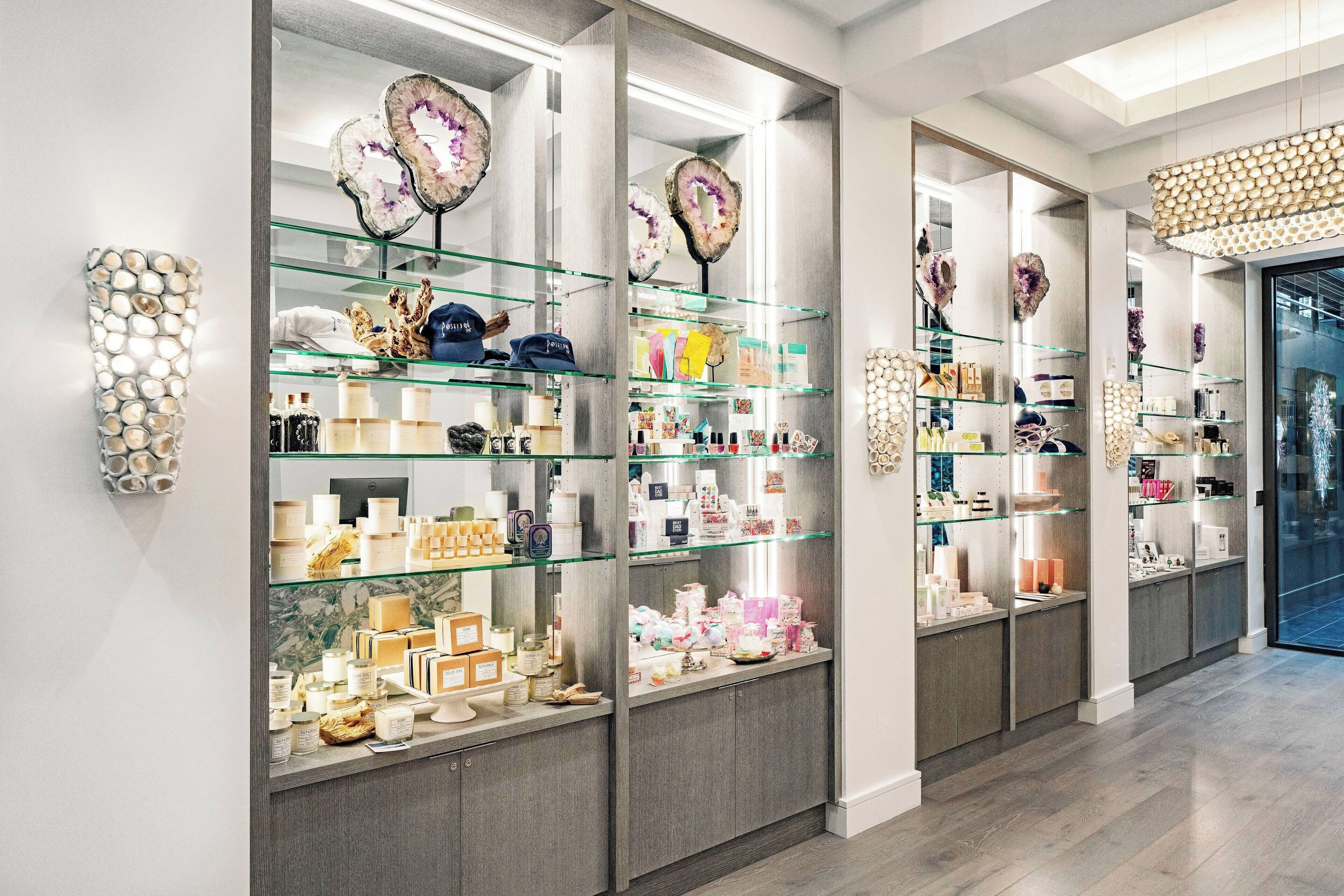 A well-lit retail space with glass display shelves and a marble wall.