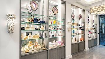 A well-lit retail space with glass display shelves and a marble wall.