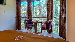 A room with a bed, two chairs, a small table with a drink, and a window with curtains. - 44 Vip Hotel (Lima)