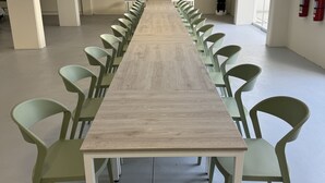 A long conference table with green chairs, white walls, and a fire extinguisher on the wall. - 44 Vip Hotel (Lima)