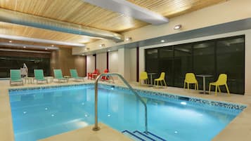 Una piscina techada, sillones reclinables de piscina
