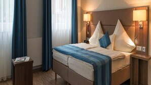 A hotel room with a bed, two bedside lamps, a nightstand, and a wooden floor. - Weinpension Haberkern (Erlenbach)