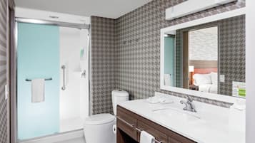 A modern bathroom with a shower, toilet, and vanity.