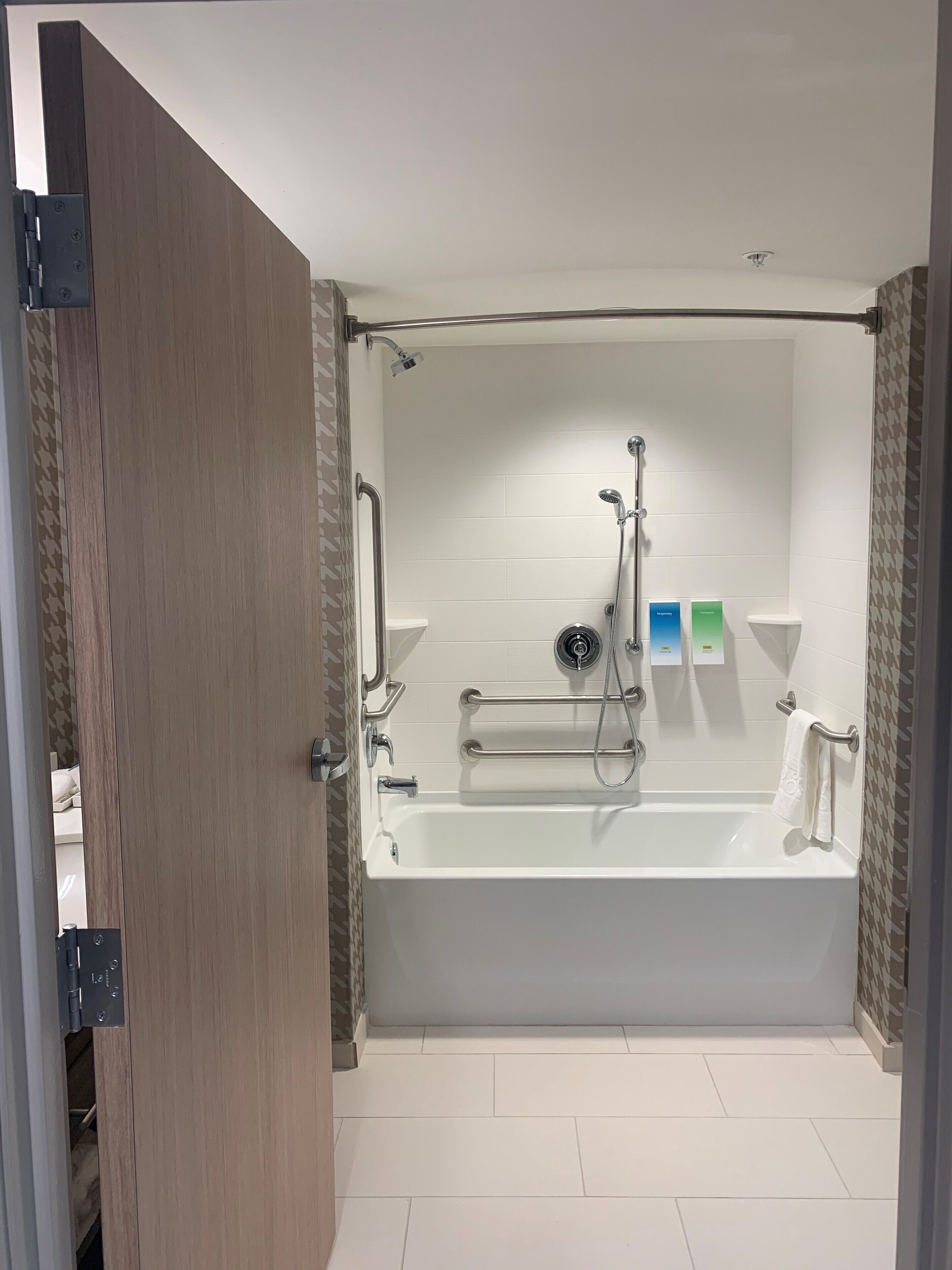 A modern bathroom with a freestanding bathtub, a showerhead, and a towel rack.