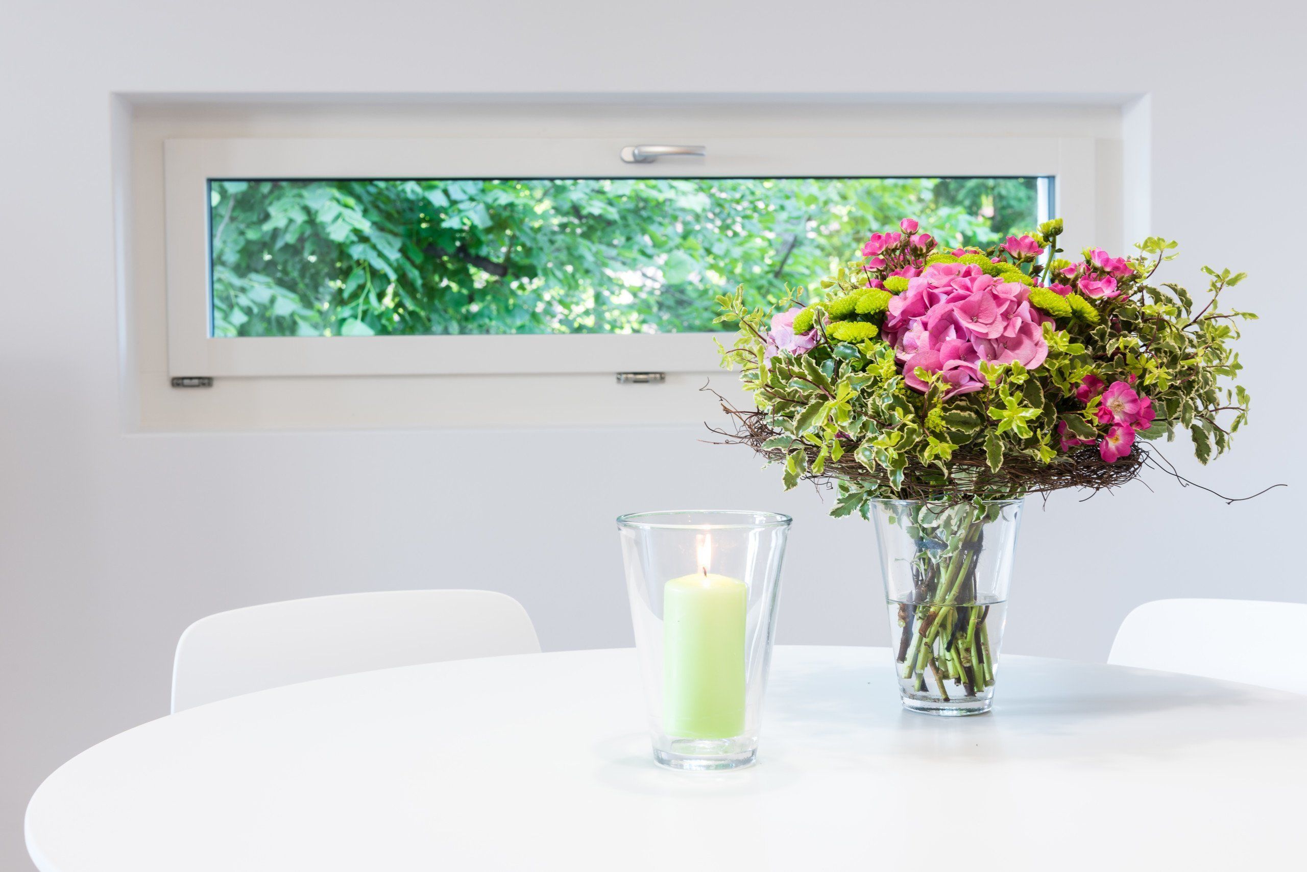 Une table avec un vase de fleurs et une bougie.