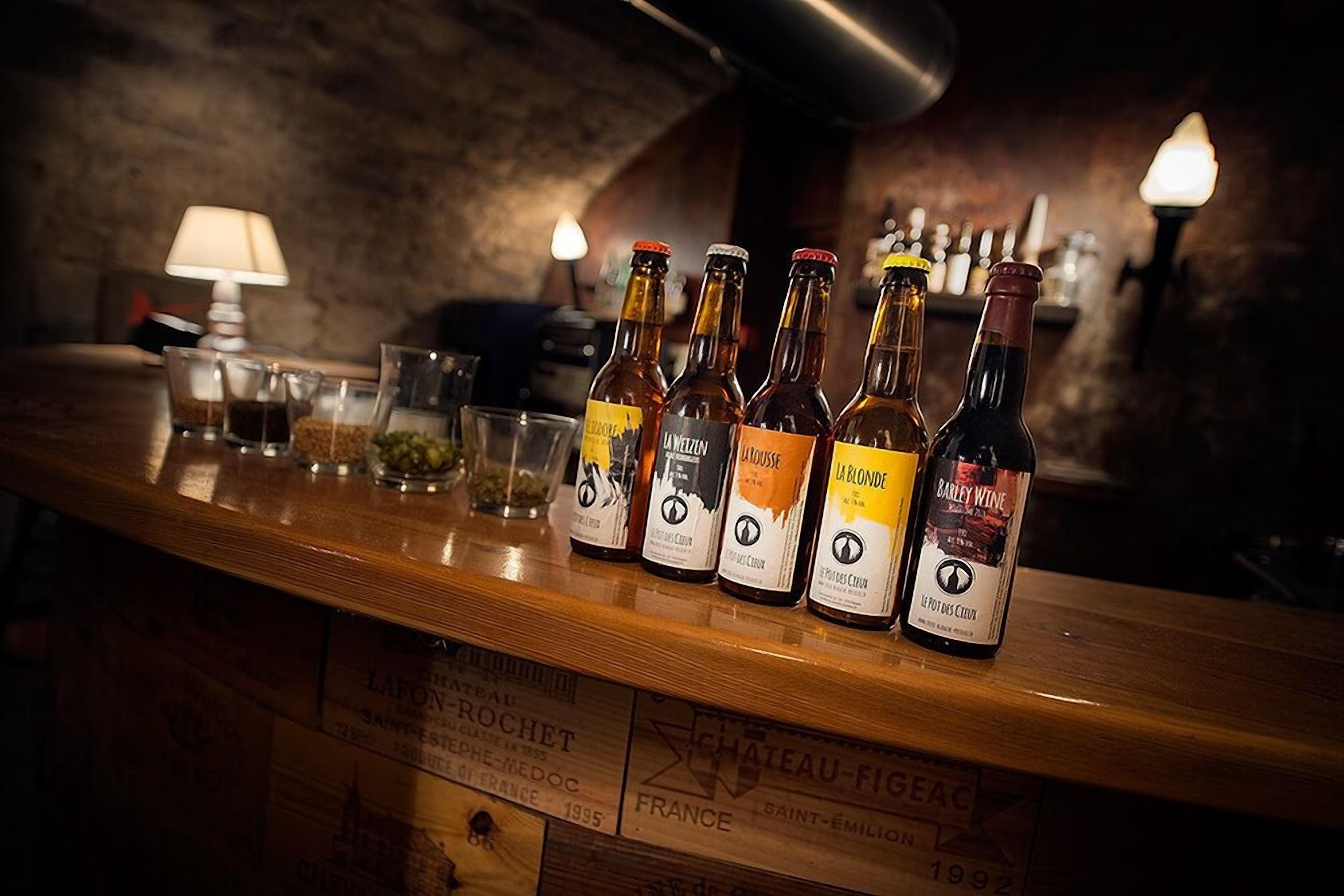 A bar counter with bottles of wine and glasses.