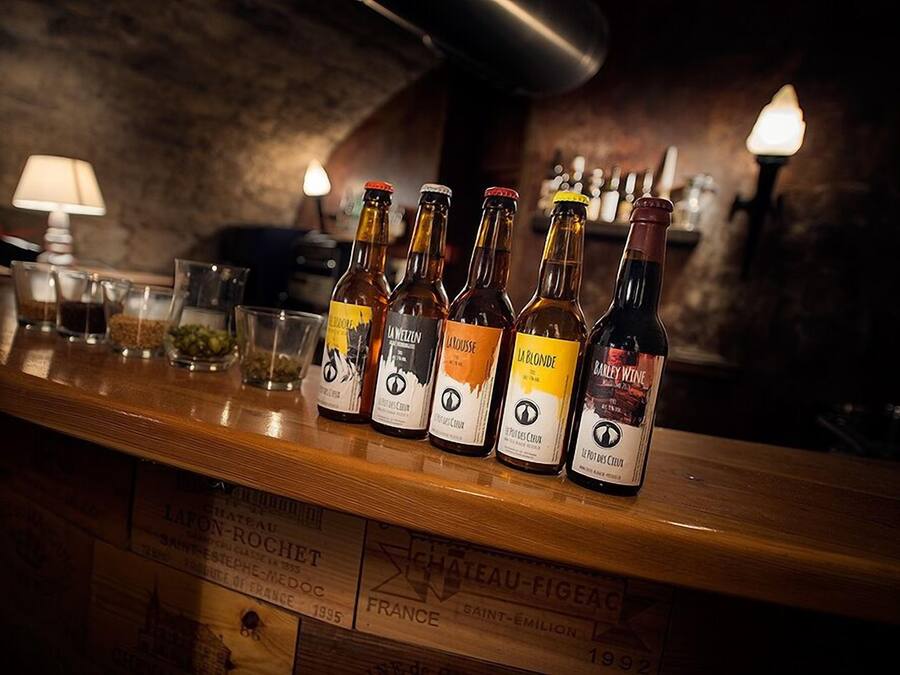 A bar counter with bottles of wine and glasses.