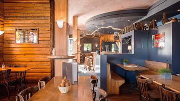 Un restaurant chaleureux avec des murs en bois et un bar central.