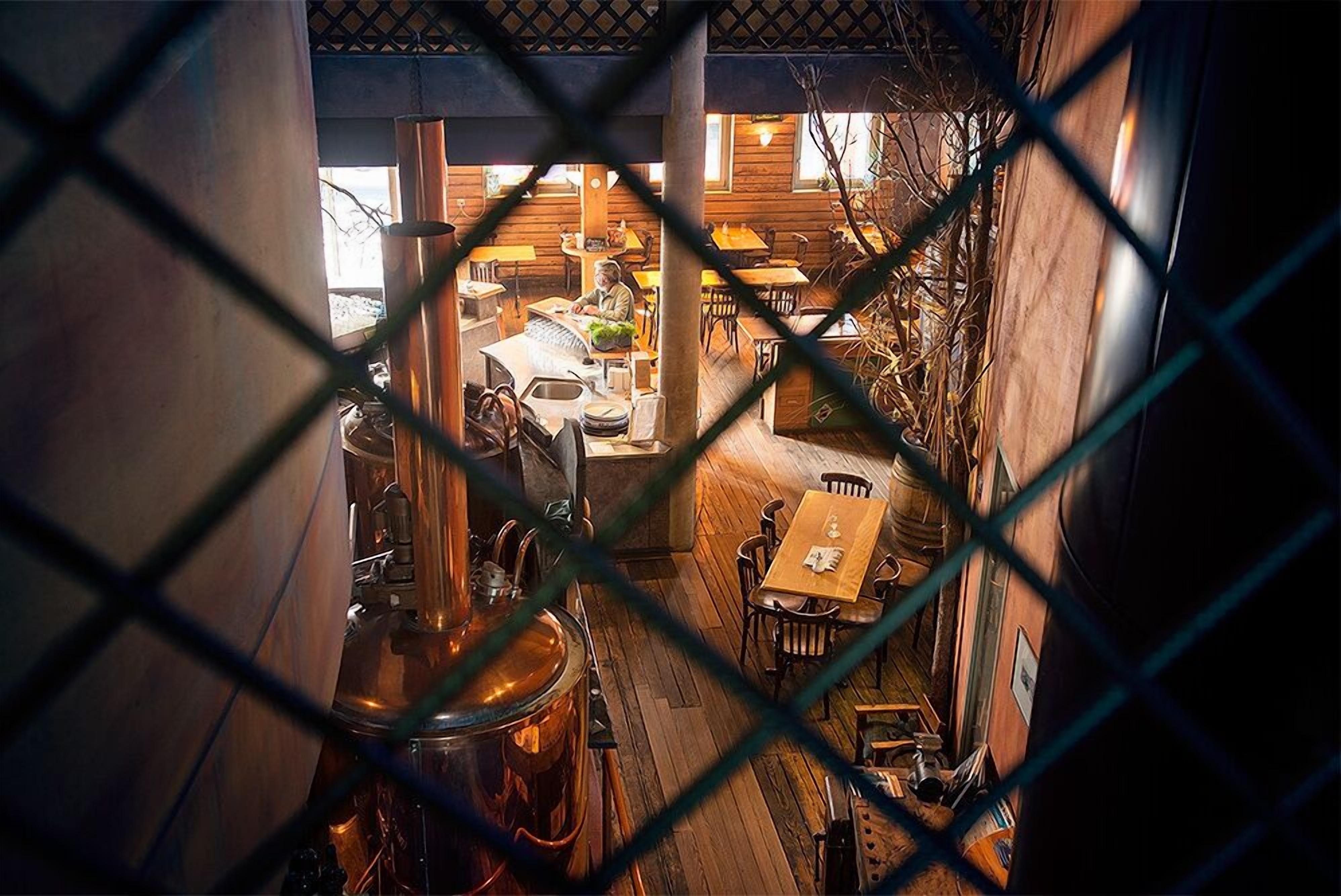 Ein gemütliches Restaurant mit Holzvertäfelungen und einem großen Kupferbraukessel.