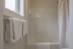 Bañera con ducha, secador de pelo, toallas, jabón
