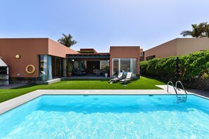 A modern pool area with a clear blue pool, lounge chairs, and a well-maintained lawn. - Salobre Golf Villas - Holiday Rental Par 4 - 8 (San Bartolomé de Tirajana)