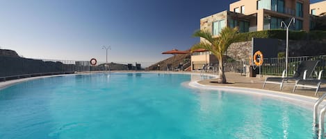 Piscine extérieure, parasols de plage, chaises longues