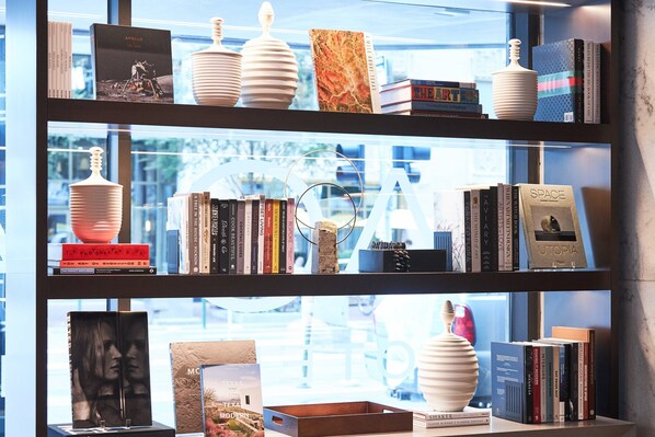 Una estantería con libros, adornos y un cuadro enmarcado.