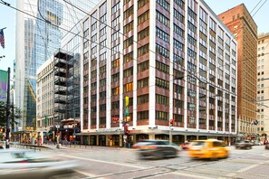A multi-story hotel with a modern facade, large windows, and a ground-level restaurant. - AC Hotels by Marriott Houston Downtown (Houston)