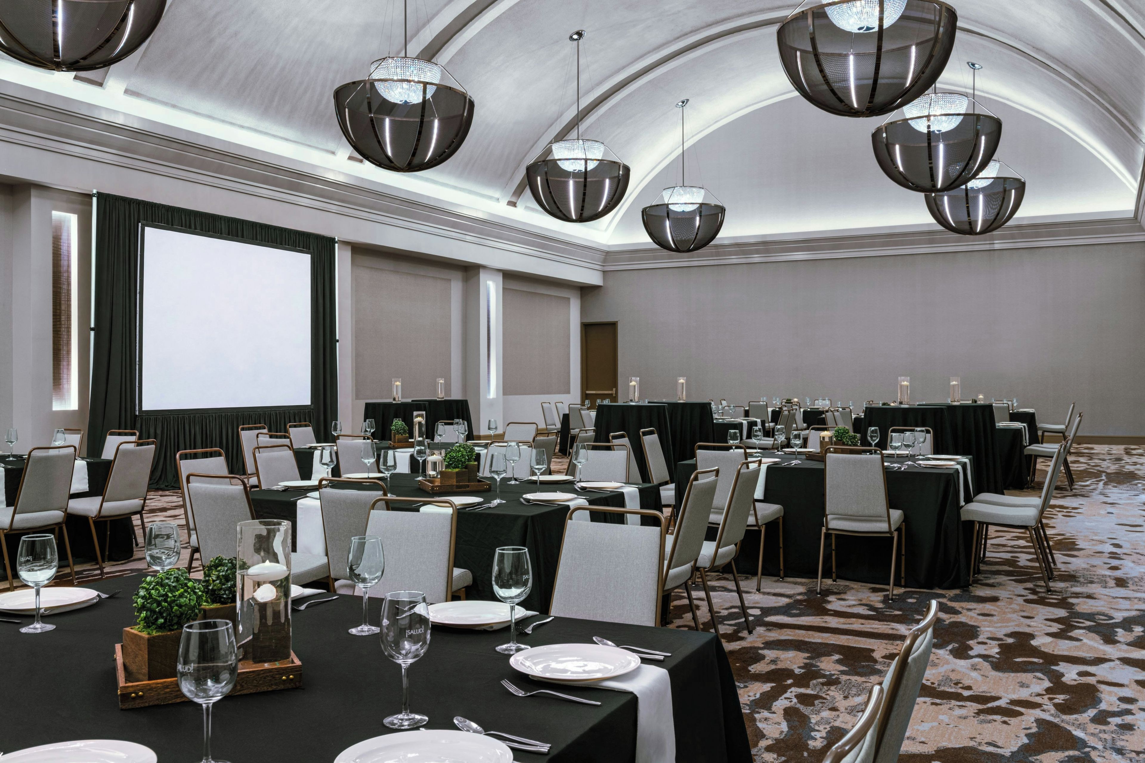 A conference room with tables set for dining, equipped with chairs and glassware.