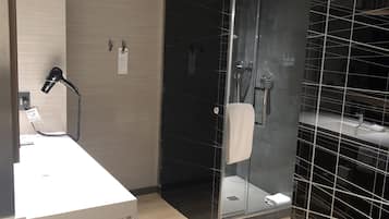 Un bany modern amb plat de dutxa de vidre, un rentapès blanc i un mirall.