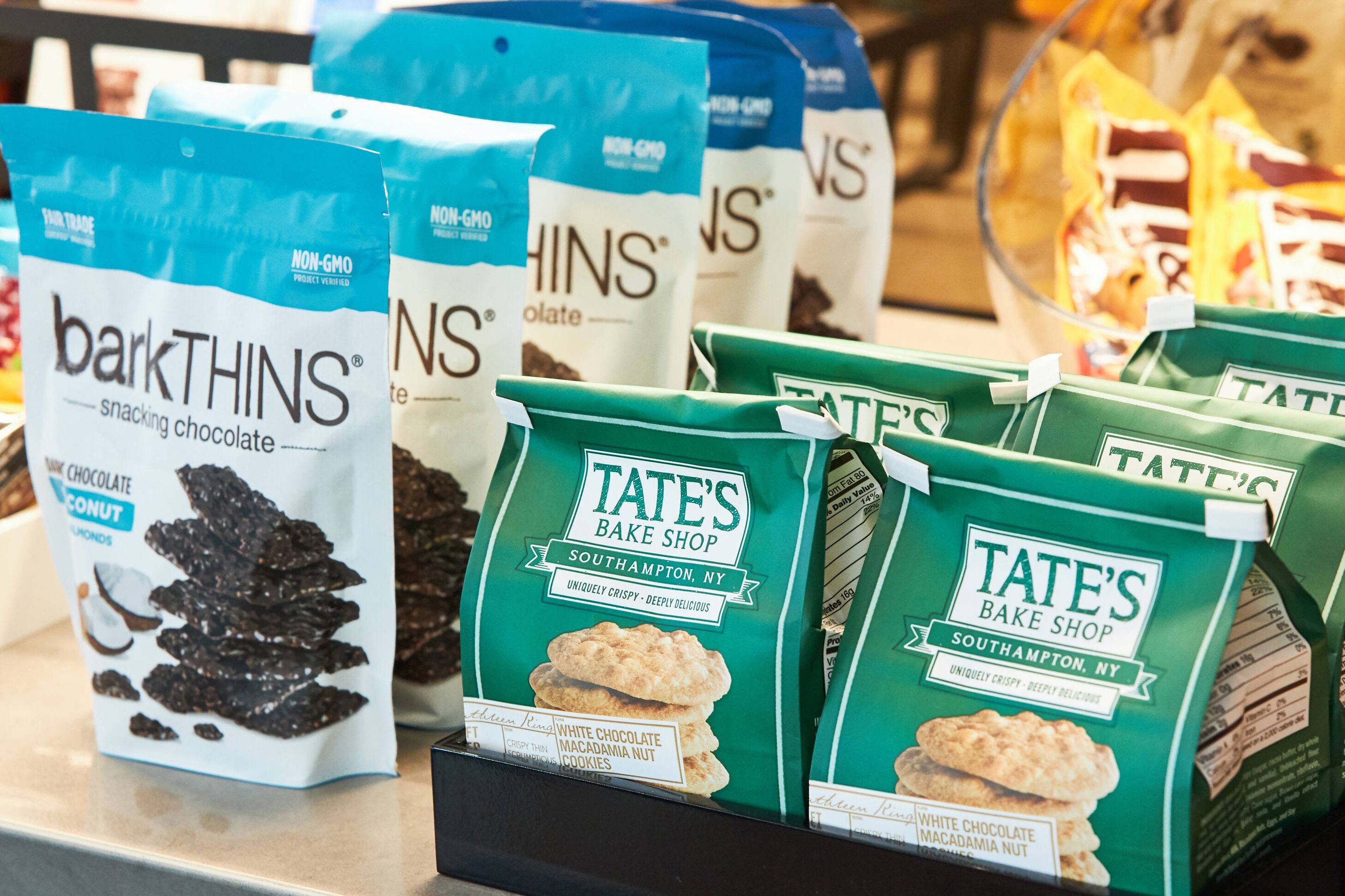 A display of snack bags including barkTHINS and Tate's Bake Shop products.