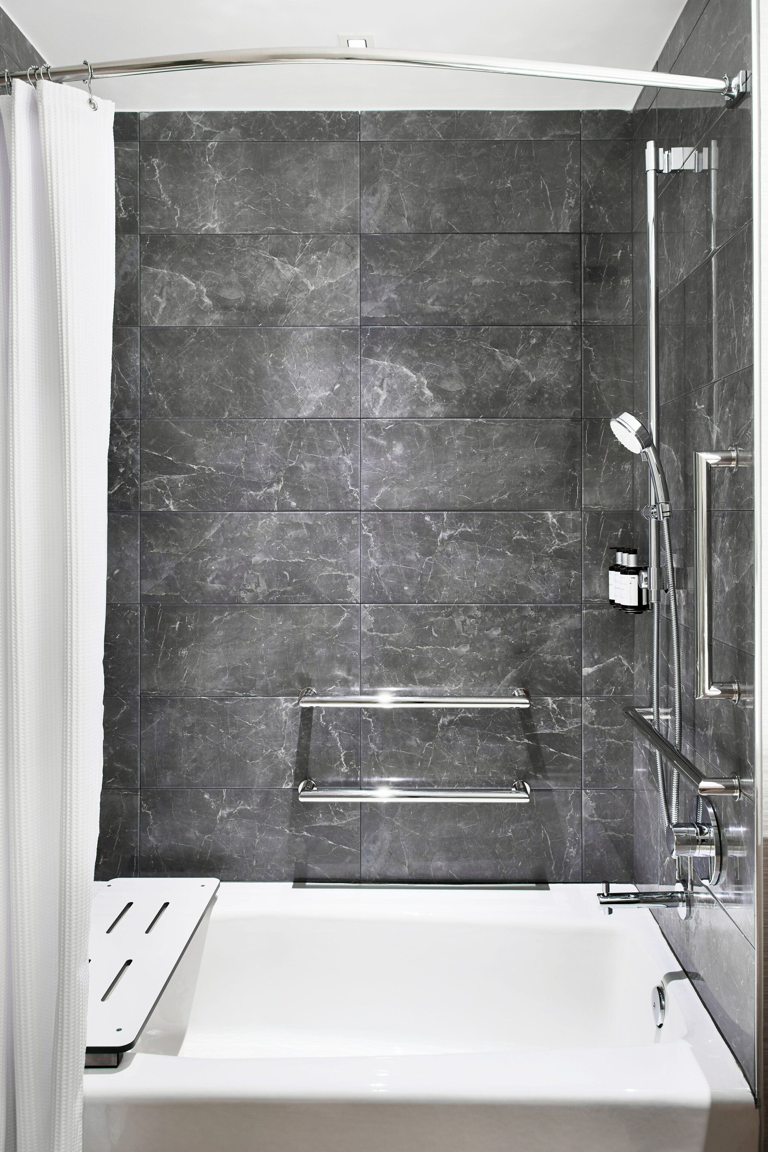 A modern bathroom with a bathtub, a shower, and a glass-enclosed shower area.