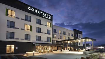 Un hôtel Courtyard by Marriott au design moderne, avec plusieurs étages et un espace d’entrée abrité.