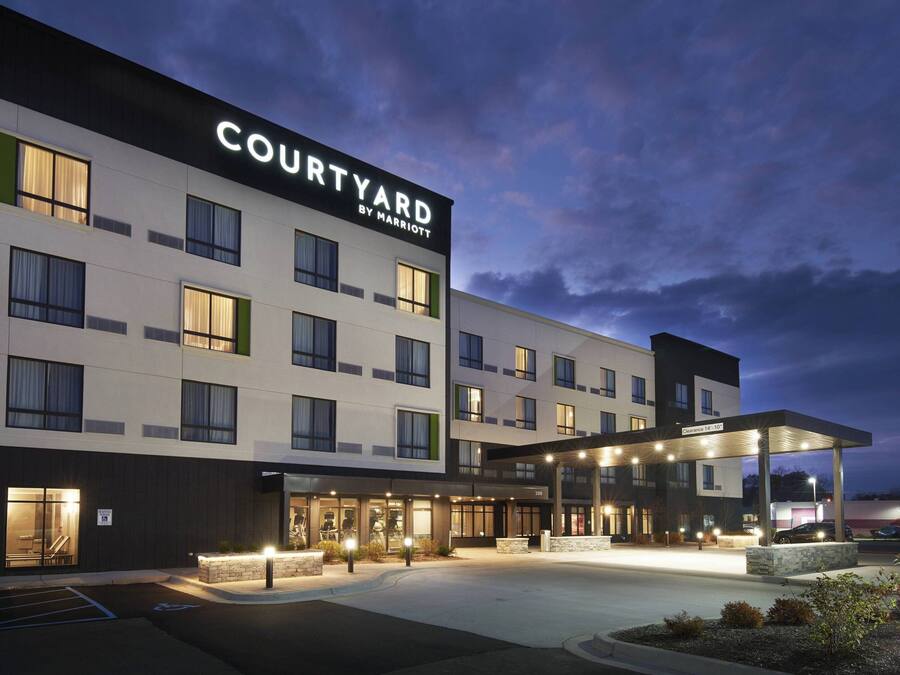 Un hôtel Courtyard by Marriott au design moderne, avec plusieurs étages et un espace d’entrée abrité.
