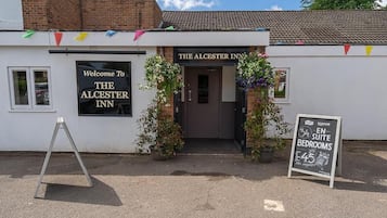 El Alchester Inn con un cartel que indica 34 habitaciones con baño privado y un precio de 45 libras por noche.