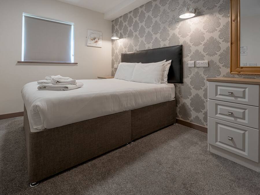 Ein Schlafzimmer mit Bett, Nachttisch und Kommode.