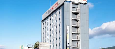 A SuperHotel building with multiple floors, a prominent sign, and a parking area.
